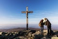 The girls are looking at a map at the top of a mountain at the cross. Bayerischer Wald Nationalpark. Mountain Lusen in the bavaria