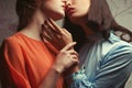 Girls in love concept. Portrait of two gorgeous girlfriends in blue and orange retro dresses making love in hotel room. Perfect Royalty Free Stock Photo