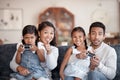 The girls love to game. Cropped portrait of an affectionate young family of four playing video games in the living room Royalty Free Stock Photo