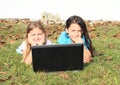 Girls lying behind a notebook Royalty Free Stock Photo