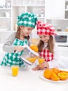 Girls making freshly squezed orange juice