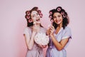 Two Girls with Hair Curlers Eating Marshmellows. Royalty Free Stock Photo