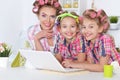 Girls and mother in hair curlers with laptop