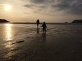 Girls and mother walking on sunset beach Royalty Free Stock Photo