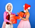 Girls open Christmas presents. Sisters in Santa Claus hats Royalty Free Stock Photo