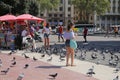 Girls feed pigeons in the Plaza Catalunya