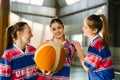 Girls play basketball on court. Sport woman with professional ball. Beautiful women posing on a court after the game