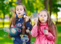 Girls play with soap bubbles in a spring time. Royalty Free Stock Photo