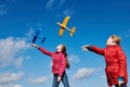 Girls playing with airplane at blue sky. Tand and childhood vacation concept