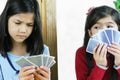 Girls playing cards, one is cheating Royalty Free Stock Photo