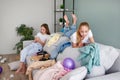 Girls are playing on a mobile phone. The room is a mess. Children scattered things in the room Royalty Free Stock Photo