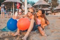 Girls playing with mobile phones on sandy beach Royalty Free Stock Photo