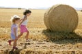 Girls playing with the round wheat dried bales Royalty Free Stock Photo