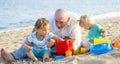 Girls playing with sand next to dad Royalty Free Stock Photo