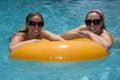 Girls in Pool Floating on Lifesaver