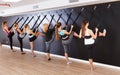 Girls practicing wall yoga with straps in studio Royalty Free Stock Photo