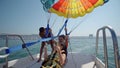 girls prepare for take off from boat at parasailing