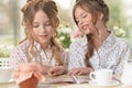 Girls reading magazine, and drinking tea Royalty Free Stock Photo