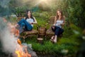 Girls with red wine glasses near bonfire