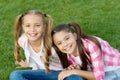 Girls rule, enjoy. Happy girls sit on green grass. Beauty look of little girls. Cute girls smile woth long hair. Beauty