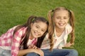 Girls rule, enjoy. Happy girls sit on green grass. Beauty look of little girls. Cute girls smile woth long hair. Beauty