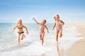 Girls running with airplane model on the seashore