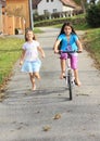 Girls running and riding a bike Royalty Free Stock Photo