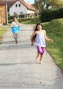 Girls running and riding a bike Royalty Free Stock Photo