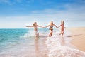 Girls running in sand and waves of sunny beach Royalty Free Stock Photo