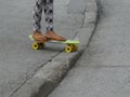 Girls`s bare dirty foots in slippers on the skateboard