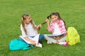 Girls school pupils doing homework together on fresh air, playful children concept