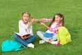 Girls school pupils doing homework together on fresh air, sisters rivalry concept
