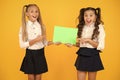 Girls school uniform hold poster. Back to school concept. Schoolgirls show poster. Social poster copy space