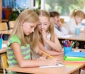 Girls sharing secrets in classroom