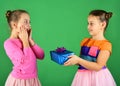 Girls with shocked faces pose with presents on green background Royalty Free Stock Photo