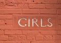 girls sign on red brick wall of ladies room in old building inside public park Royalty Free Stock Photo