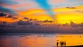 Girls silhouettes at the waters edge against breathtakingly beautiful sunset