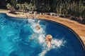 Girls sisters diving in water on home backyard pool. Children siblings friends enjoying and having fun in swimming pool together.