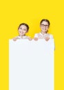 Girls sisters holding white empy poster and smiling. Girls Holding White Advertisement Board
