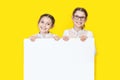 Girls sisters holding white empy poster and smiling. Girls Holding White Advertisement Board