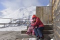 Girls-sisters sit in an embrace on steps of the wooden house in mountains Royalty Free Stock Photo