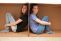 Girlfriends separated through moving boxes