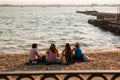 Girls sitting on the beach at sunset.