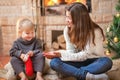 Girls sitting fireside opening Christmas presents Royalty Free Stock Photo