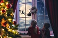 Girls sitting by window and looking at Santa Royalty Free Stock Photo