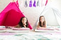 Girls Smiling While Resting In Tipi Tents During Sleepover