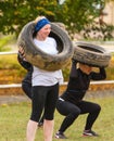 Girls squat with the tire.