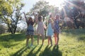Girls Standing With Arms Raised and Sunlight Overhead