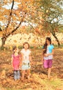 Girls standing barefoot under falling leaves