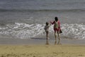 Girls standing on the beach surrounded by the sea at Lanzarote island in Spain